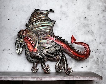 May include: A black and red dragon figurine with glitter accents. The dragon has wings, a long tail, and sharp claws. It is standing on a gray surface.