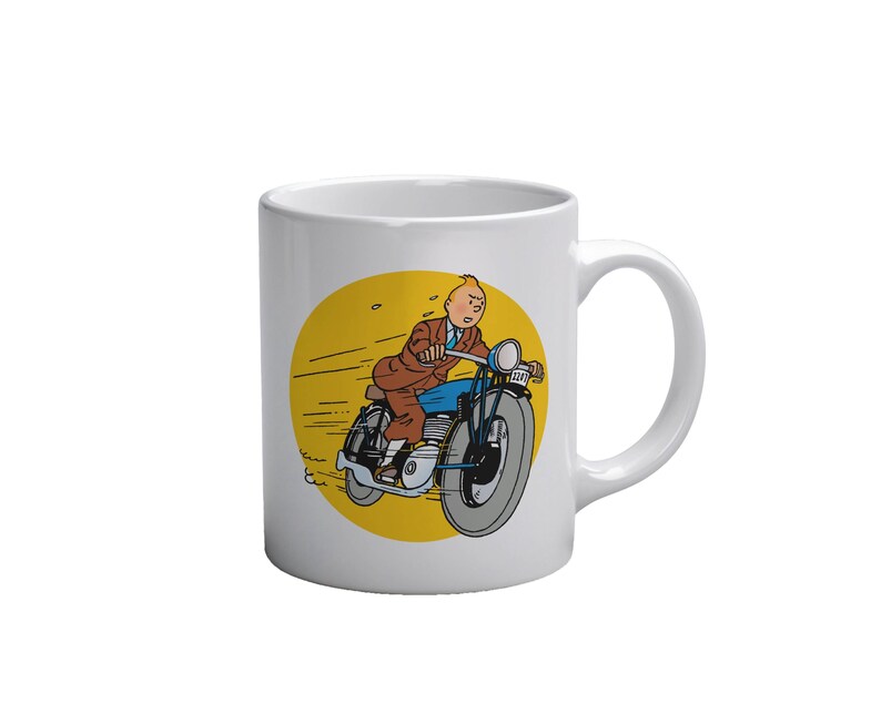 Puede incluir: Taza de cer&aacute;mica blanca con una ilustraci&oacute;n de dibujos animados de un hombre montando una motocicleta azul sobre un fondo amarillo. El hombre lleva un traje marr&oacute;n y una corbata azul. La taza tiene un asa curva.