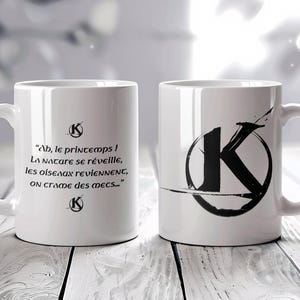 Peut inclure: Deux tasses en céramique blanche avec des lettres noires. Une tasse présente une lettre K noire dans un cercle avec un design de trait de pinceau noir. L'autre tasse a une citation en français qui se lit comme suit : "Ab, le printemps ! La nature se réveille, les oiseaux reviennent, on crame des mecs..."