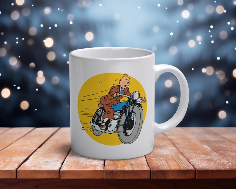 Puede incluir: Taza de cer&aacute;mica blanca con una ilustraci&oacute;n de dibujos animados de un hombre en motocicleta. La imagen est&aacute; sobre un c&iacute;rculo amarillo. El hombre lleva un traje marr&oacute;n y pantalones azules. La taza tiene un asa curvada.