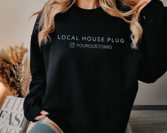 May include: Black sweatshirt with the text "LOCAL HOUSE PLUG" and the Instagram logo with the text "YOURCUSTOMIG" in white.