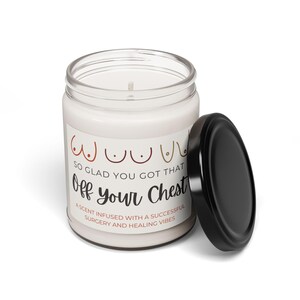 K&ouml;nnte beinhalten: Eine wei&szlig;e Kerze in einem Glasgef&auml;&szlig; mit schwarzem Deckel. Das Etikett auf dem Gef&auml;&szlig; lautet "SO GLAD YOU GOT THAT Off your Chest" mit einer Grafik von drei Br&uuml;sten. Das Etikett lautet auch "A scent infused with a successful surgery and healing vibes."