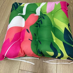 a pair of colorful cushions on a wooden floor