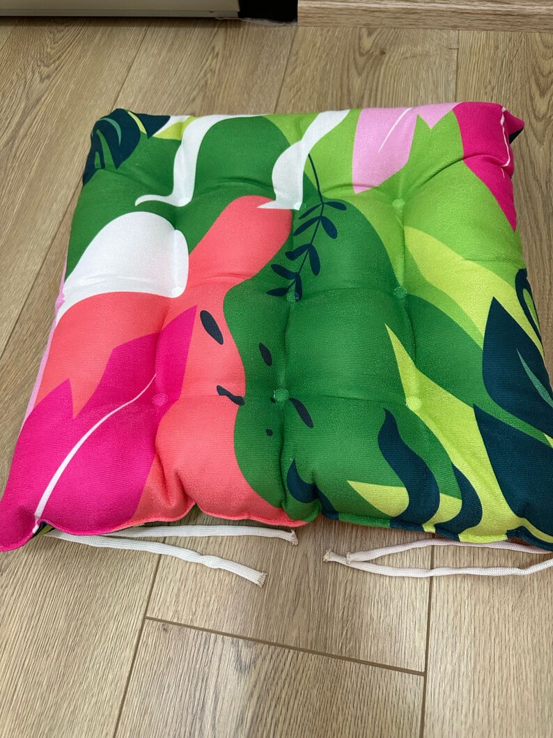 a pair of colorful cushions on a wooden floor