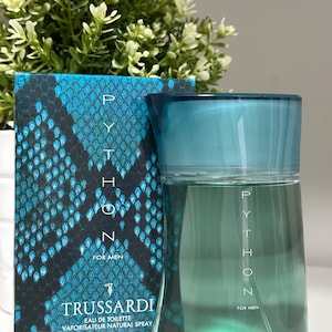 Op de afbeelding: Een blauwe glazen fles Trussardi Python Eau de Toilette met een slangenhuidpatroon op de doos. De fles bevat 100 ml en de doos heeft de tekst "Voor mannen".