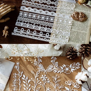 Puede incluir: Un conjunto de bordes de encaje de papel blanco y dise&ntilde;os florales. Los bordes de encaje son de varios patrones y tama&ntilde;os. Los dise&ntilde;os florales incluyen tallos, hojas y flores.