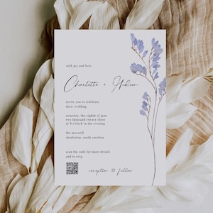 Może przedstawiać: Zaproszenie ślubne z akwarelowym wzorem kwiatowym w odcieniach fioletu i błękitu. Zaproszenie jest na ślub Charlotte i Hudsona w sobotę, 8 czerwca 2023 roku o godzinie 16:00 w The Maxwell w Charleston, Karolina Południowa. Dołączono kod QR z dodatkowymi informacjami i możliwością potwierdzenia obecności.