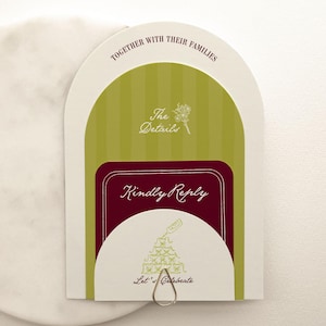 May include: A wedding invitation with a green and white striped background, a burgundy section that says "Kindly Reply", and a white semi-circle with the words "Let's Celebrate". The invitation is attached to a white marble circle.
