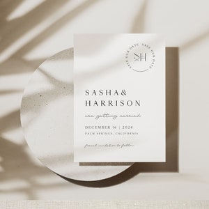 May include: A minimalist save the date card with a white background and black text. The card features the couple's names, "Sasha & Harrison", and the date of their wedding, "December 16, 2024". The location, "Palm Springs, California", is also included. The card has a simple design with a circle at the top that says "Save Our Date" with the initials "SH" in the center.