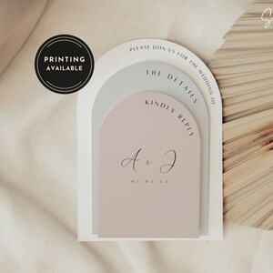 May include: Wedding invitation suite with a layered arch design in neutral tones. The invitation includes the text "Please join us for the wedding of", "The Details", "Kindly Reply", and the initials "A & J" with the date "07.01.21". A circular badge reads "Printing Available".