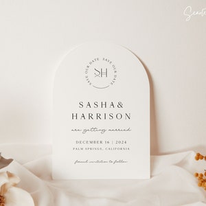 May include: White save the date card with an arch shape. The card features a monogram with the initials "SH" in a circle. The text reads "Sasha & Harrison are getting married December 16, 2024 Palm Springs, California formal invitation to follow".