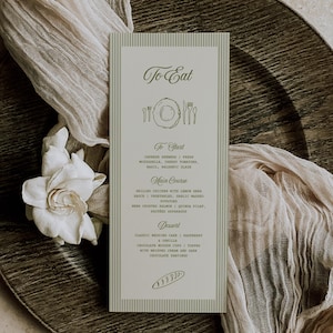 May include: A wedding menu card with a green and white striped design. The menu includes sections for starters, main courses, and desserts. The card is on a dark wooden charger plate with a white flower and draped fabric.