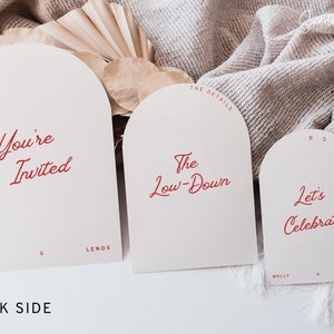 May include: Three white arched cards with red text. The first card says "You're Invited" with the names "Molly & Lenox" at the bottom. The second card says "The Low-Down" with "The Details" at the top. The third card says "Let's Celebrate" with "RSVP" at the top and "Molly & Lenox" at the bottom.