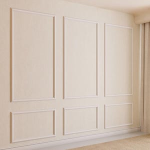 May include: A white wall with a decorative molding pattern. The molding is in a grid pattern with three rows and three columns. The wall is painted a light cream color.