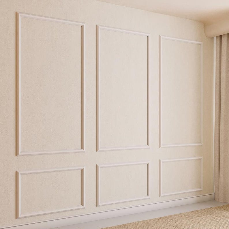 May include: A white wall with a decorative molding pattern. The molding is in a grid pattern with three rows and three columns. The wall is painted a light cream color.