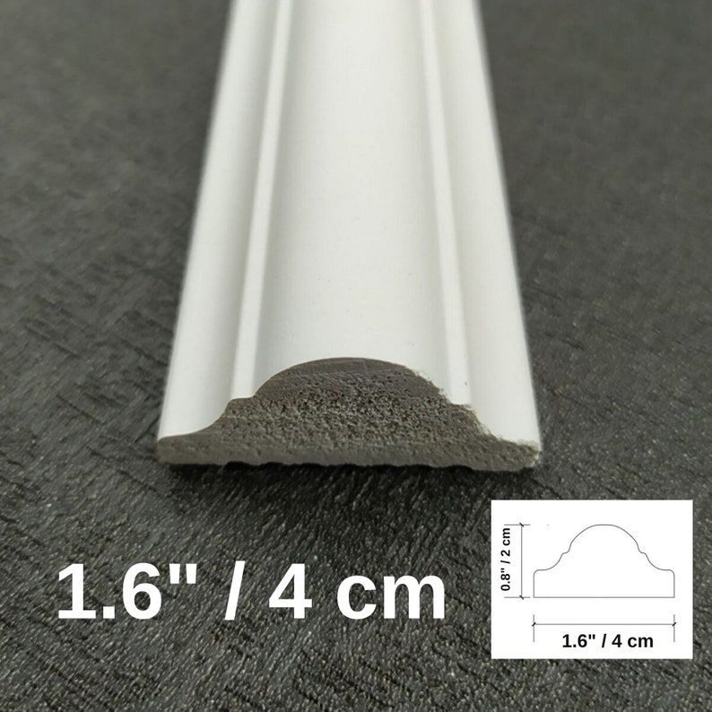 May include: A white decorative molding strip with a curved profile. The cross-section shows a width of 1.6 inches and a height of 0.8 inches. The piece features a smooth finish and a textured base, clearly displaying its dimensions in inches.
