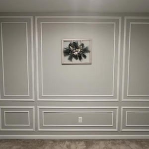 May include: A rectangular wooden window frame wall decoration featuring a central arrangement of dark green pine needles, silver-toned foliage, and a cluster of small, round, white and silver ornaments mounted on the center of the frame.