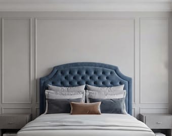 May include: A blue tufted headboard with a curved top edge, featuring a button-tufted design. The bed is dressed with white linens, two light gray pillows, two dark gray rectangular pillows, and one small rectangular brown accent pillow.