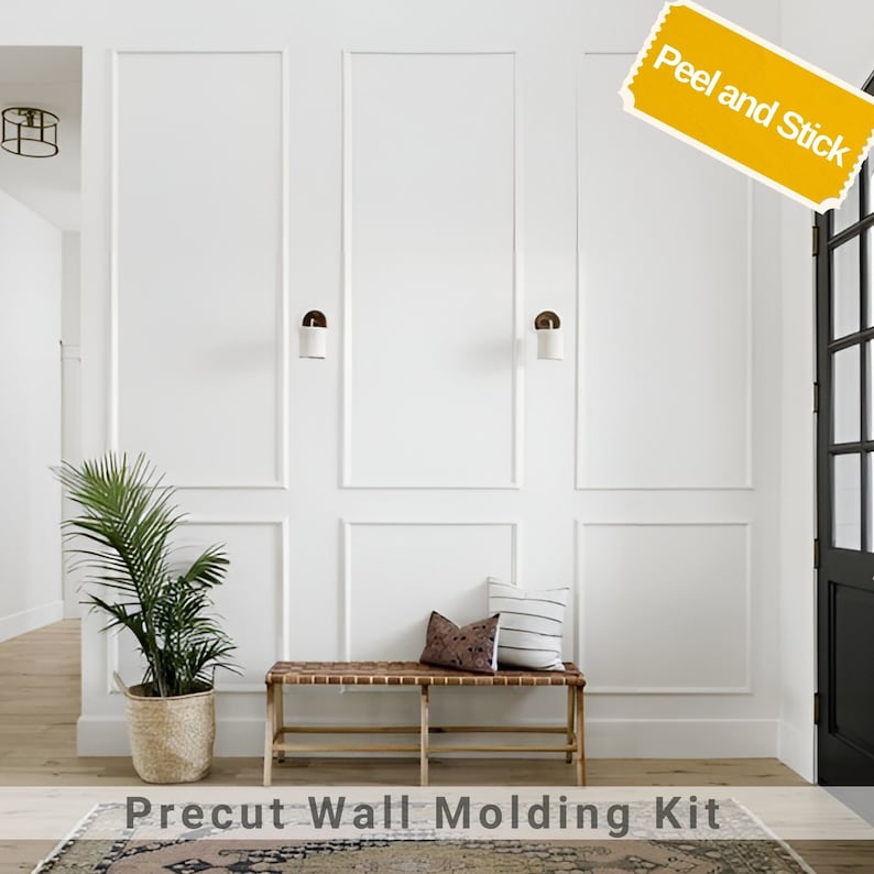 K&ouml;nnte beinhalten: Wei&szlig;e Wand mit vorgefertigten Wandleisten-Set, zum Abziehen und Aufkleben, in einem Flur mit einer Bank und einer Pflanze. Der Text "Precut Wall Molding Kit" befindet sich auf dem Boden.