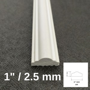May include: A white decorative molding strip with a curved profile. The piece measures 1 inch in width and 0.5 inches in height, as indicated by the text and the technical diagram showing the dimensions of 1 inch by 0.5 inches.