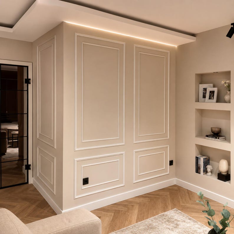 K&ouml;nnte beinhalten: Eine beige Wand mit rechteckigen Zierleisten, einem eingelassenen Regal mit drei Ebenen f&uuml;r B&uuml;cher, gerahmte Fotos und Deko-Objekte sowie einer schwarz gerahmten Glast&uuml;r, alles &uuml;ber einem hellbraunen Fischgr&auml;t-Parkettboden.