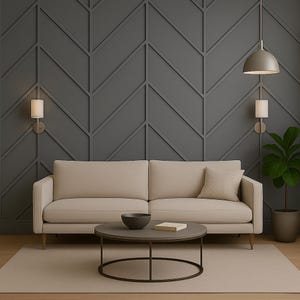 May include: A beige sofa with a matching throw pillow sits in front of a dark gray accent wall with a geometric pattern. A round coffee table with a dark bowl and book is in front of the sofa. A potted plant and two wall sconces complete the room.