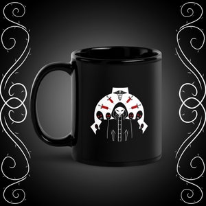 May include: Black ceramic coffee mug with a white design of a hooded figure with a medical symbol and syringes. The figure is surrounded by six other figures with red eyes.