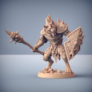 May include: A miniature figurine of a wolf-like creature wearing armor and holding a spiked spear and a shield. The figurine is made of a light brown plastic and is posed in a fighting stance.
