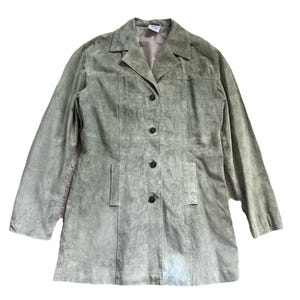 May include: A sage green suede blazer with a classic notched collar and button-down closure. The long-sleeved jacket features two front pockets and a tailored fit. The blazer is a versatile piece for layering.