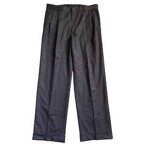 Könnte beinhalten: Dunkelgraue Hose in Anthrazit mit hoher Taille, doppelten Vorderfalten, zentralem Reißverschluss, Gürtelschlaufen am Bund und umgeschlagenen Säumen am unteren Ende des geraden Beins, präsentiert in einer einfarbigen, matten Optik.