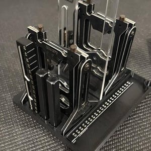 Könnte beinhalten: Ein schwarzes und silbernes Präzisionswerkzeug mit transparenten Acrylkomponenten. Das Werkzeug verfügt über eine Basis mit Messmarkierungen, mehrere verstellbare Arme und vertikale Stützen. Konzipiert für präzise Messungen und Ausrichtung.