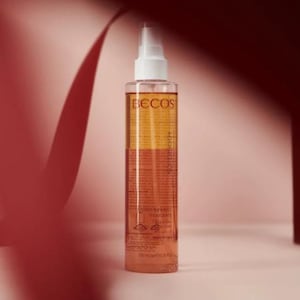 Può includere: Un flacone spray trasparente con tappo bianco e il marchio "BECOS". Il flacone contiene un liquido bicolore, con una parte superiore color ambra e una inferiore rosso-arancio. Il flacone è etichettato "UPPERBODY" e "CORPO REMODELANTE".