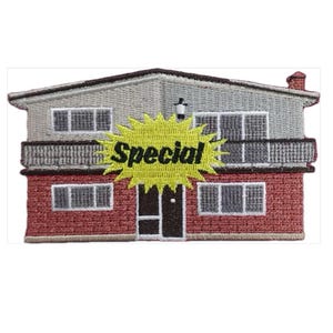 May include: Embroidered patch depicting a two-storey house with a red brick facade and grey siding. A yellow burst with the word "Special" in black is superimposed. The patch has a brown roof and trim.