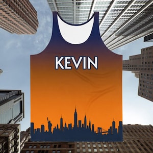 May include: A sleeveless vest with an orange and navy blue gradient design. The word "KEVIN" is printed in white block letters. A dark blue silhouette of the New York City skyline is at the bottom of the vest.