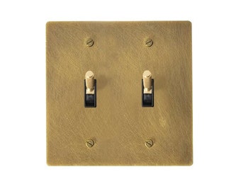 Toggle light switch with aged brass wall plate