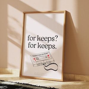 Puede incluir: Una impresión enmarcada en blanco con el texto "for keeps? for keeps." y una ilustración en blanco y negro de una cinta de casete con el texto "Shannon's Songs for Tommy" y corazones rojos. El texto "Johnny & Maureen Binding & Keeping 13" está en la parte inferior de la impresión.