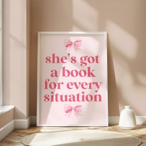 Framed pink wall art featuring the quote She’s Got a Book for Every Situation with feminine bow accents, perfect for book lovers, reading nooks, and cozy decor. Book Merch, Harry Styles Merch, Bookish Prints, Coquette Decor, Aestethic wall art
