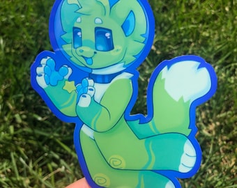 Puede incluir: Un personaje de dibujos animados verde y azul que lleva un casco espacial azul y sostiene una estrella amarilla. El personaje tiene una cola blanca y flota en el espacio. La pegatina está impresa sobre un fondo transparente.