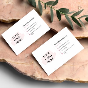 May include: Two white business cards with a pink logo placeholder that says "YOUR LOGO HERE". The text on the cards reads "Francisco Andrade, Brand Owner, hello@reallygreatsite.com, www.reallygreatsite.com, +123-456-7890, 123 Anywhere St., Any City, ST, 12345".