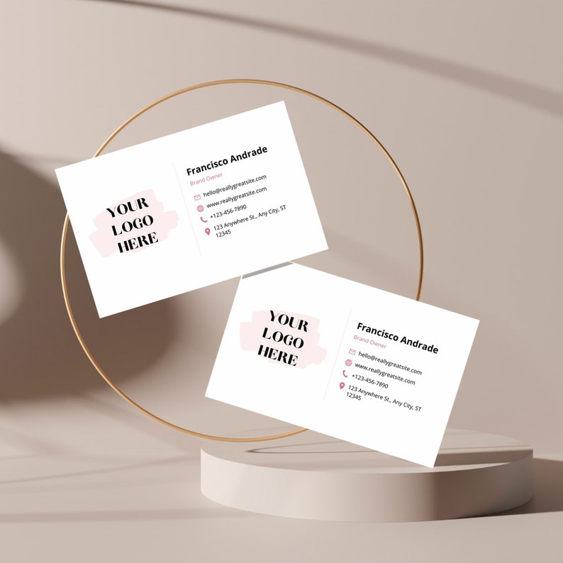 May include: A white business card with a pink watercolor-style logo that says "YOUR LOGO HERE". The text on the card reads "Francisco Andrade, Brand Owner, hello@reallygreatsite.com, www.reallygreatsite.com, +123-456-7990, 123 Anywhere St. Any City, ST 12345".