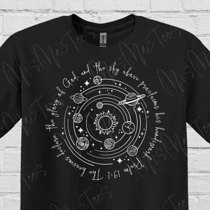 May include: Black t-shirt with a white graphic of a solar system with the text "The glory of God and the sky above proclaim His handiwork. Psalm 19:1"