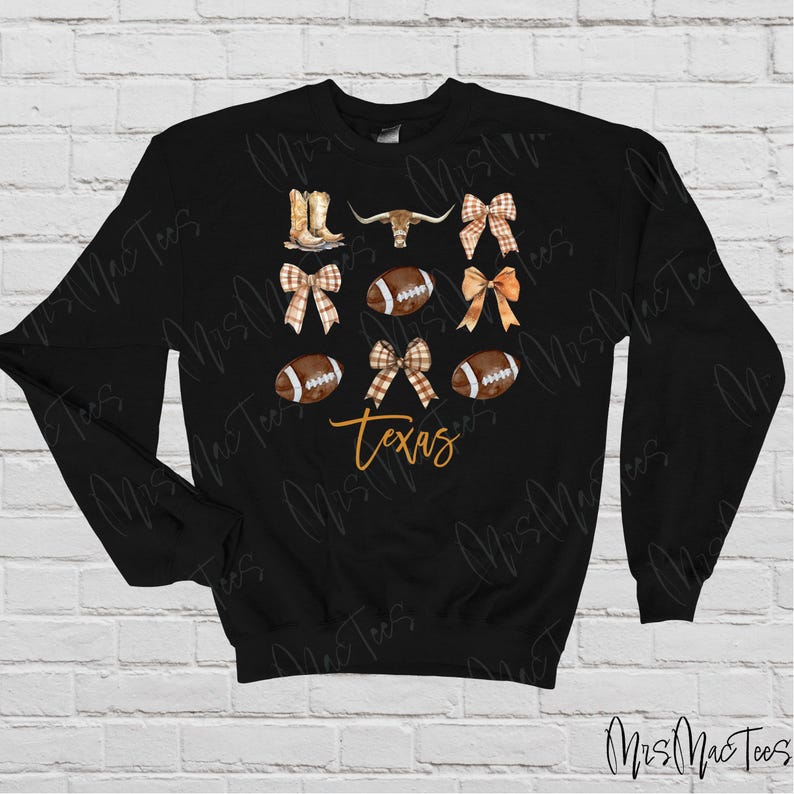 May include: Black sweatshirt with a design featuring a brown steer head, footballs, boots, and bows in brown and white plaid. The text "Texas" is written in orange.