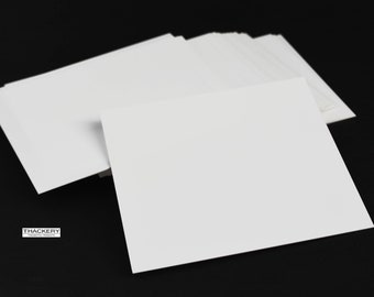 May include: A stack of white blank cards on a black background. The cards are rectangular and have a smooth surface.
