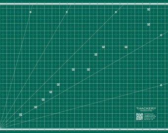 Könnte beinhalten: Eine grüne, selbstheilende Schneidematte mit weißen Gitterlinien und diagonalen Linien. Die Matte hat einen weißen Rand und ein weißes Etikett mit dem Text "THACKERY PRECISION CUTTING" und einem QR-Code.