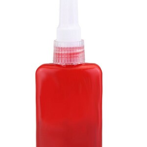 May include: A red bottle of glue with a white applicator tip. The bottle has a clear plastic cap with a red ring.
