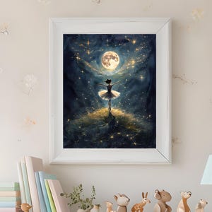 May include: A framed art print depicts a ballerina under a full moon surrounded by stars. The artwork features a dark blue and gold color palette, with the ballerina in a white tutu. The frame is white.