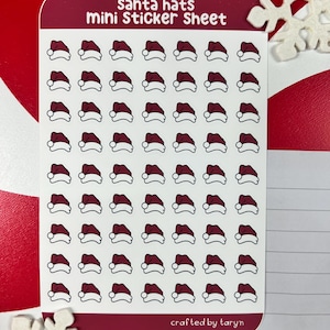 May include: A sheet of mini stickers featuring 64 red and white Santa hats. The sheet is white with a burgundy border and the text "Santa hats mini Sticker Sheet" at the top. The text "crafted by taryn" is at the bottom.