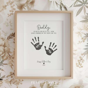 May include: Framed print with the text "Daddy, no matter how big or tall I grow, always remember my tiny fingers and toes." Includes two handprints and "Happy Father's Day 202X". The frame is light brown.