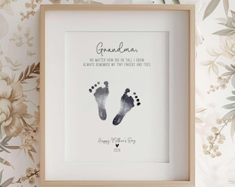 May include: A framed print with a light wood frame. The print features two grayscale baby footprints and the text "Grandma, no matter how big or tall I grow always remember my tiny fingers and toes." The words "Happy Mother's Day" and the year 202X are also included.