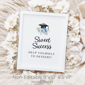 May include: A white framed sign with the text "Sweet Success" and "Help Yourself to Dessert!" features a graduation cap and floral accents. The sign is surrounded by white flowers, perfect for a graduation party.